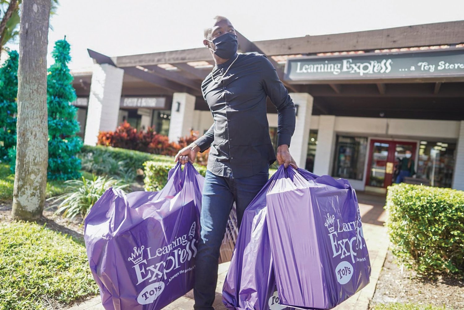 Santonio Holmes leaves the Learning Express with bags of toys for Belle Glade teens.